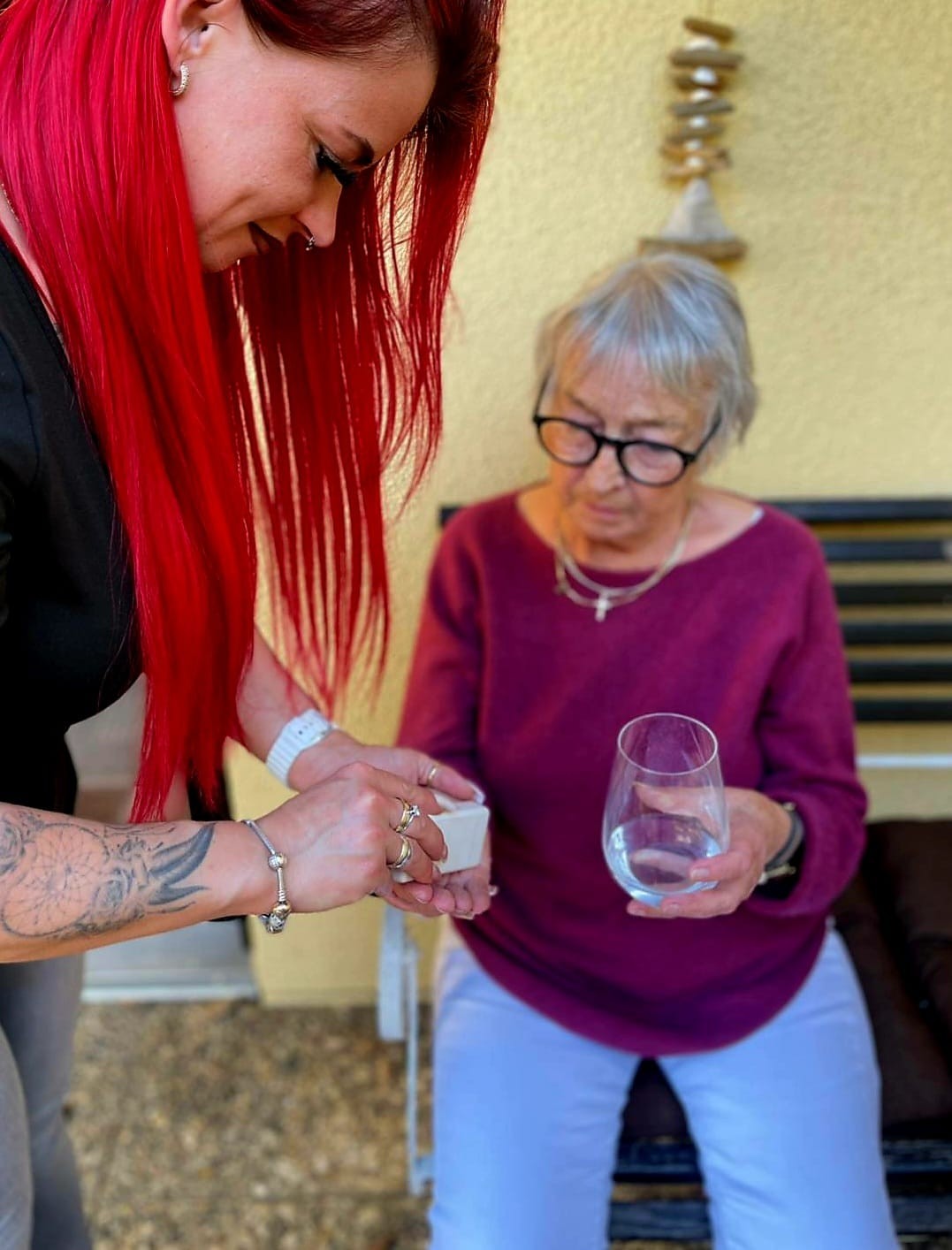 Pflegerin Joanna Weinert reicht einer Patientin ihre Medikamente